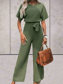 Olive green short-sleeve jumpsuit with adjustable cinch belt, front view on a light background.