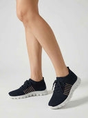 Navy blue cushioned mesh orthopaedic trainers with beige stripe detailing and white soles, worn on feet, angled view.