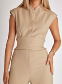 Tan jumpsuit with cap sleeves and a wide waist tie, front view on a white background.