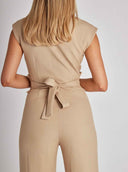 Tan jumpsuit with tied belt at waist, back view.