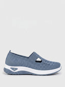 Blue knit slip-on trainer with white sole, side view on a white background.