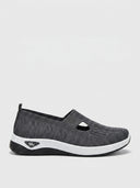 Dark grey knit slip-on trainer with white sole, side view on a light background.