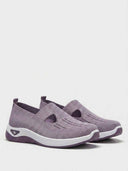 Pair of lavender knit slip-on trainers with cut-out strap detail and white chunky soles, angled view on white background.