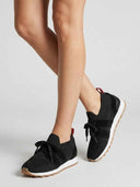 Black mesh trainers with knit upper, white cushioned midsole, and gum tread outsole, angled three-quarter view on a light background.