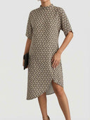 Tan and black patterned knee-length dress with short sleeves and mock neck, front view.