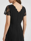 Black midi dress with lace cap sleeves and scalloped V-neck back, angled view.