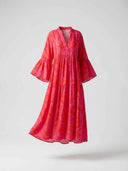 Red and pink patterned mini dress with bell sleeves and tiered skirt, front view on gray background.