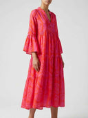 Red and pink patterned tiered mini dress with bell sleeves, front view.