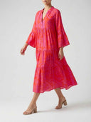 Red and pink patterned tiered mini dress with bell sleeves, angled front view.
