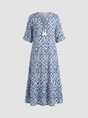 Blue and white ikat print maxi dress with tassels, front view on a light background.