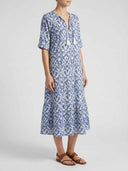 Blue and white ikat print maxi dress with tassels, side view.